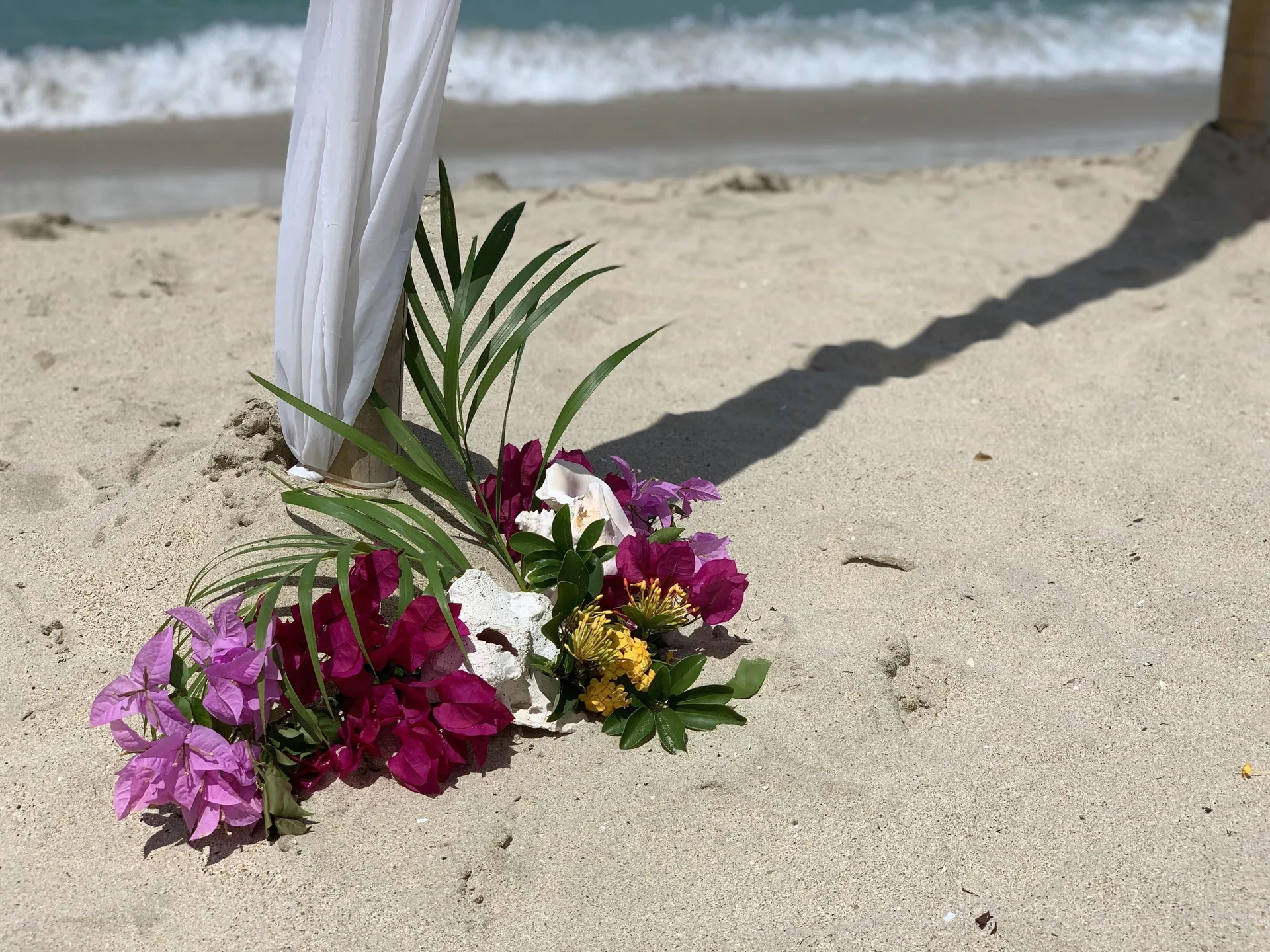 Tropical flowers at a beach ceremony arch at Emerald Beach Resort.