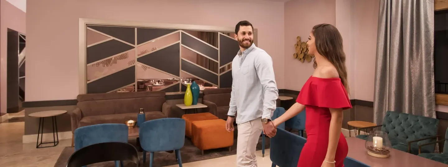 Couple walking through a stylish lobby lounge at Emotions by Hodelpa Puerto Plata.