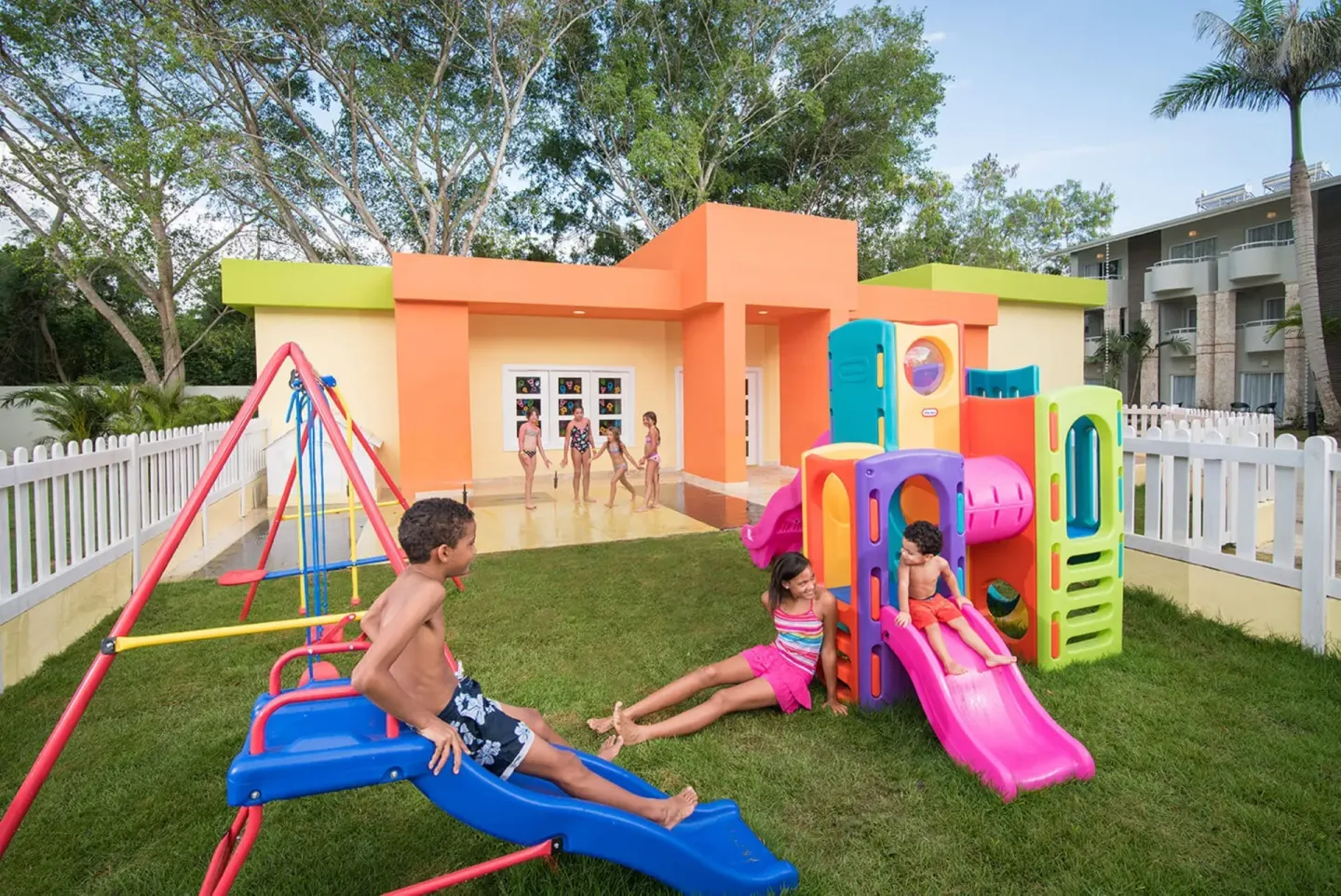Children playing on colorful outdoor play equipment at Emotions by Hodelpa Puerto Plata.