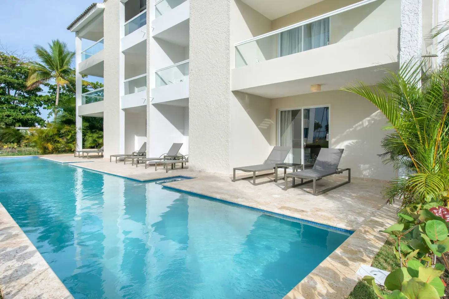 Poolfront building with balconies and lounge chairs at Emotions by Hodelpa Puerto Plata.