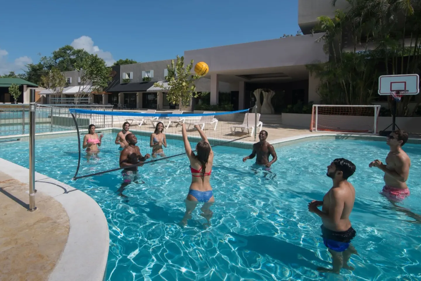 Guests play water volleyball in a pool at Emotions by Hodelpa Puerto Plata.
