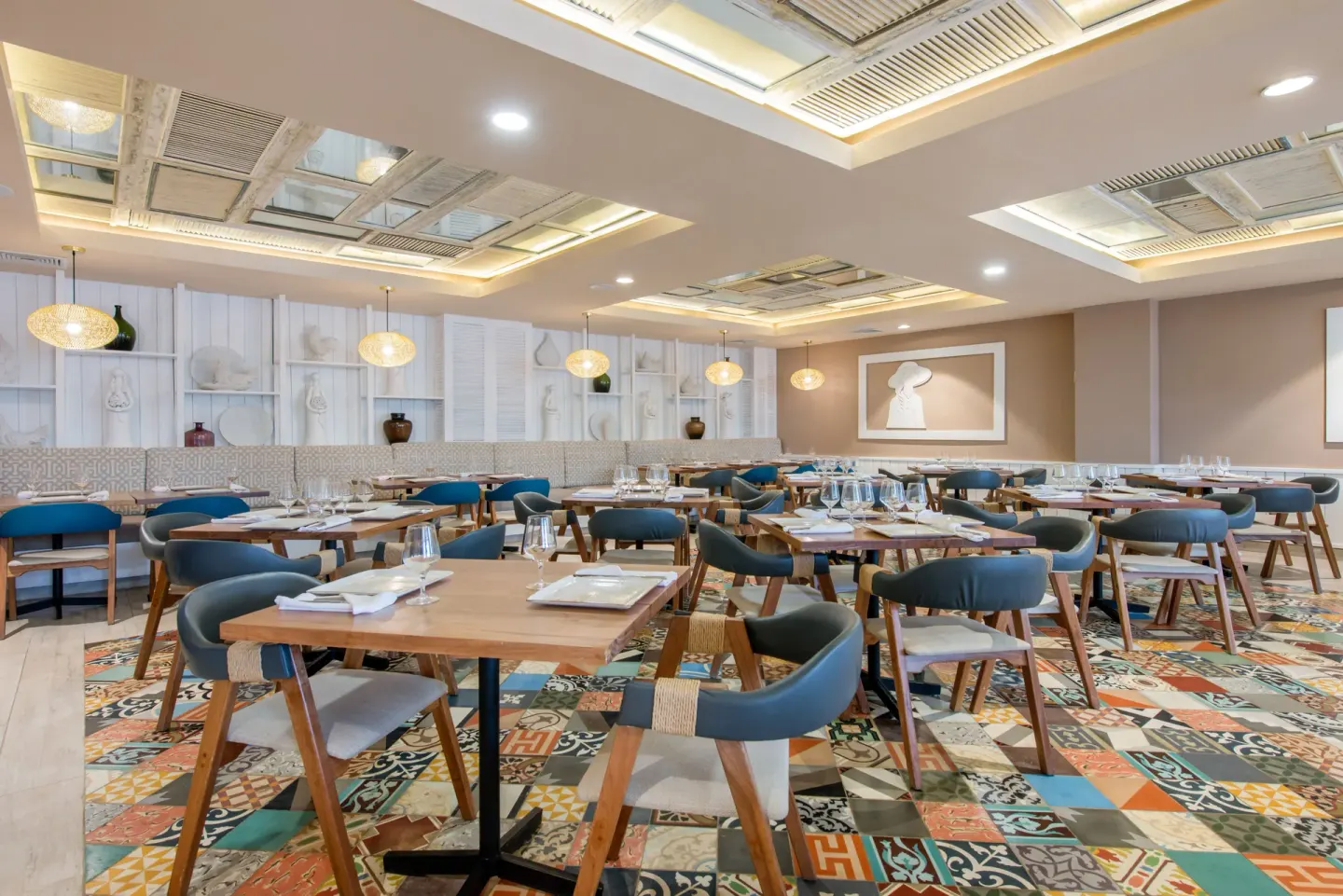 Dining room with set tables and patterned tile floor at Emotions by Hodelpa Puerto Plata.