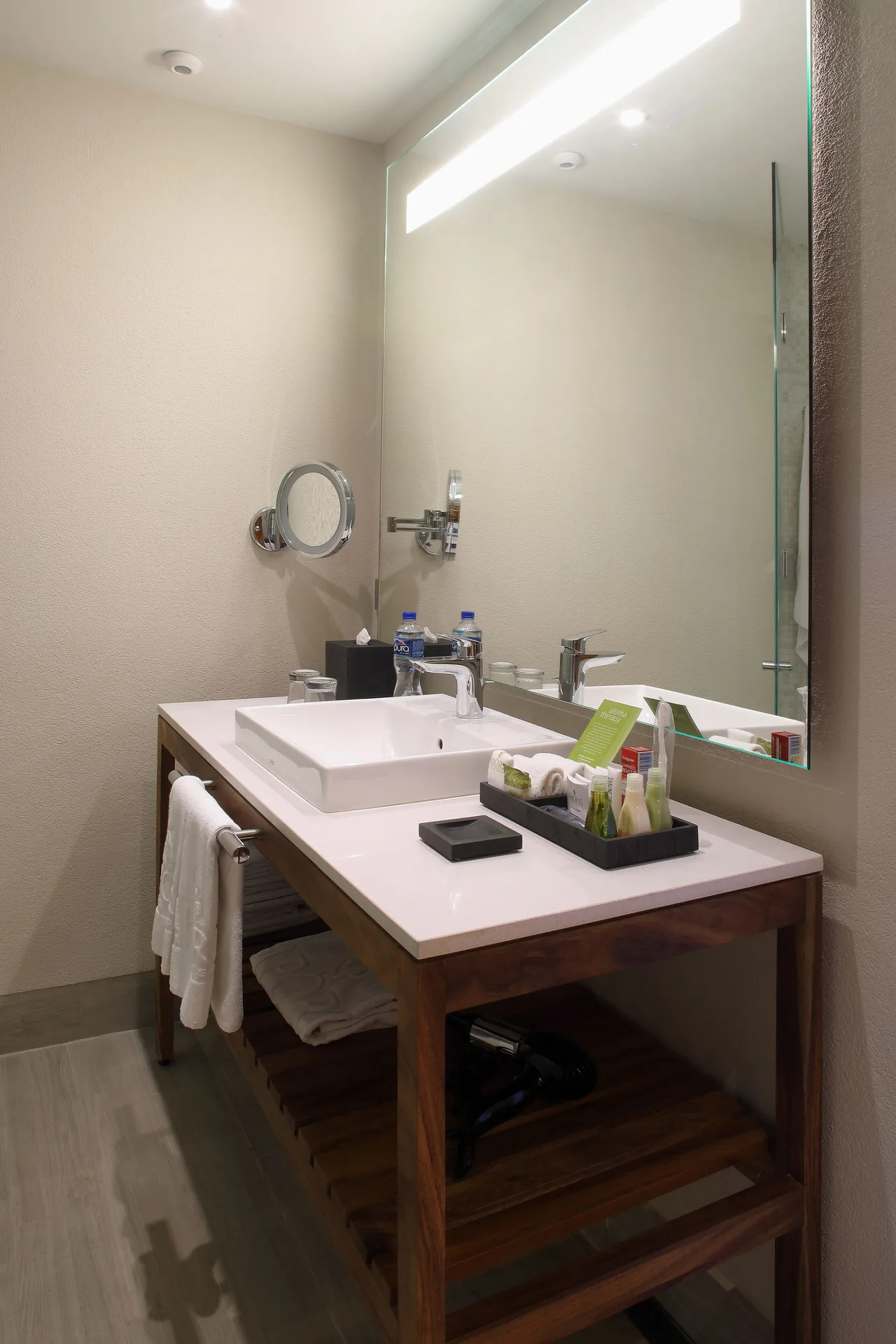Bathroom vanity with square sink, large mirror, towels, and amenities at Emporio Cancun.