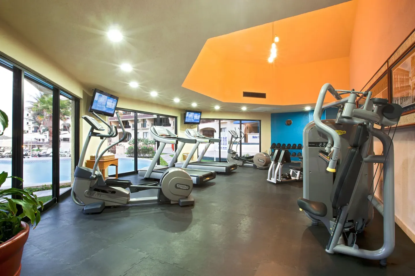 Fitness room with treadmills, ellipticals, weights, and strength equipment at Emporio Cancun.