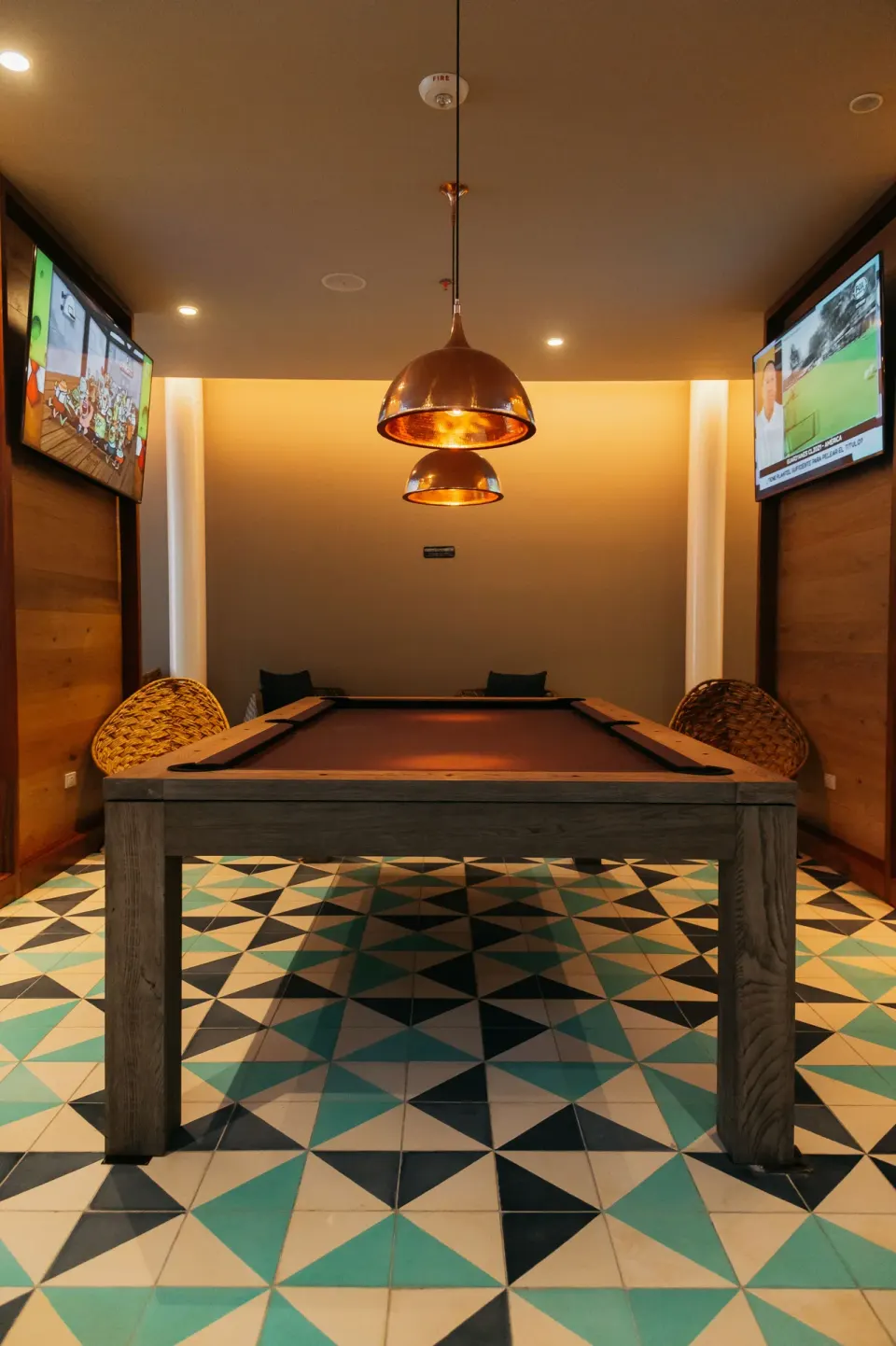 Game room with a pool table, pendant lights, and wall-mounted TVs at Emporio Cancun.
