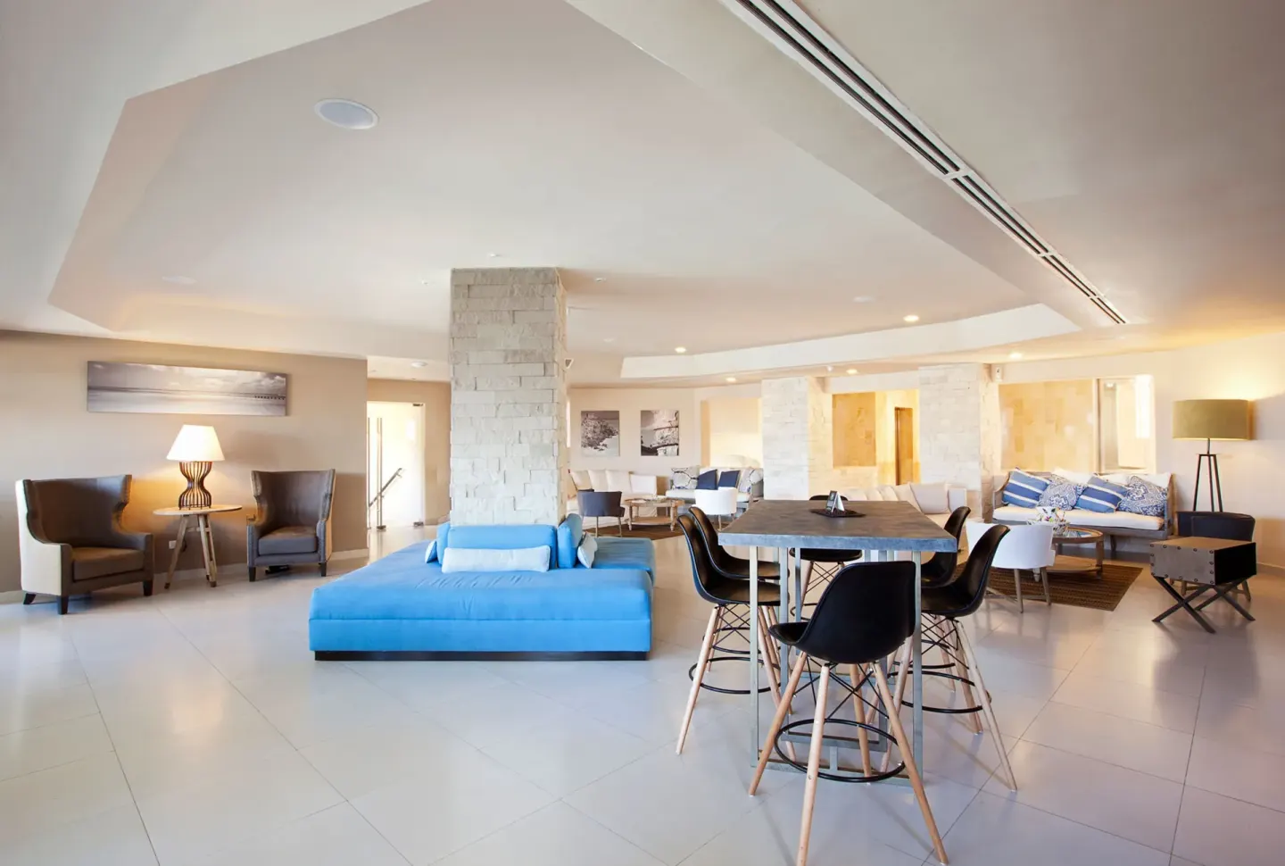Open lobby lounge with seating areas and a communal table at Emporio Cancun.