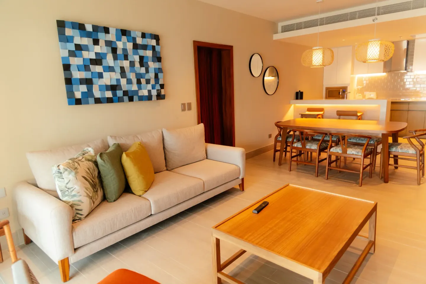 Living and dining area with sofa, table, and kitchen at Emporio Cancun.