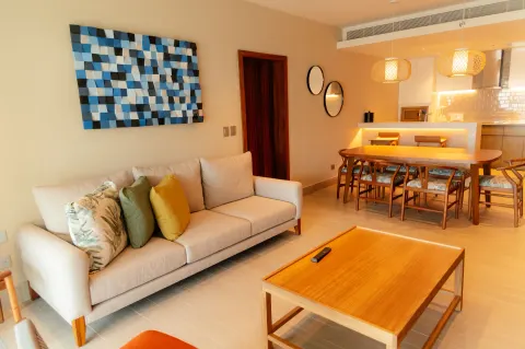 Living and dining area with sofa, table, and kitchen at Emporio Cancun.