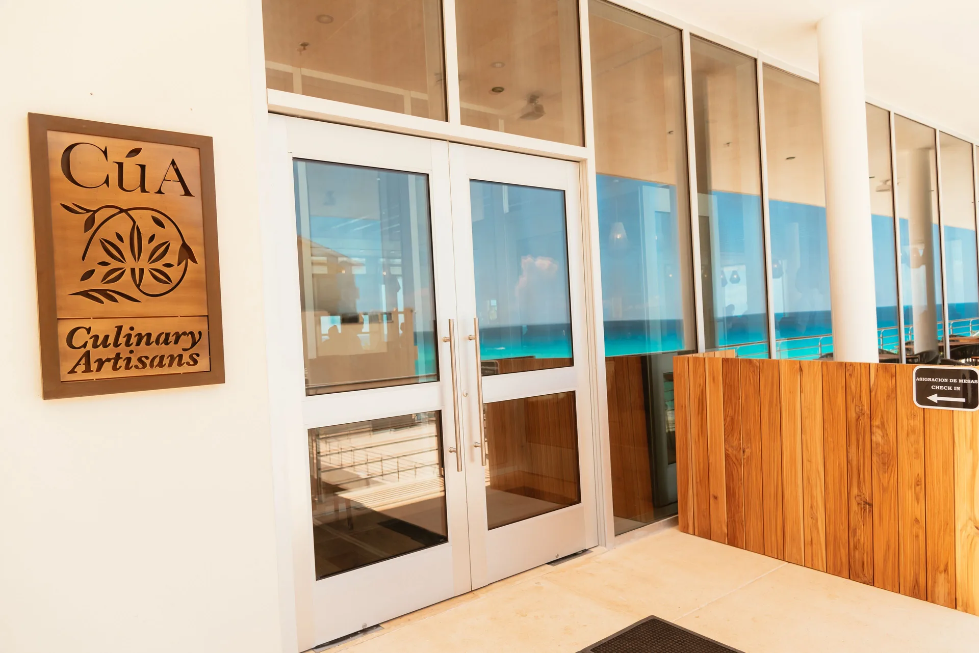 CúA Culinary Artisans entrance sign and glass doors at Emporio Cancun.