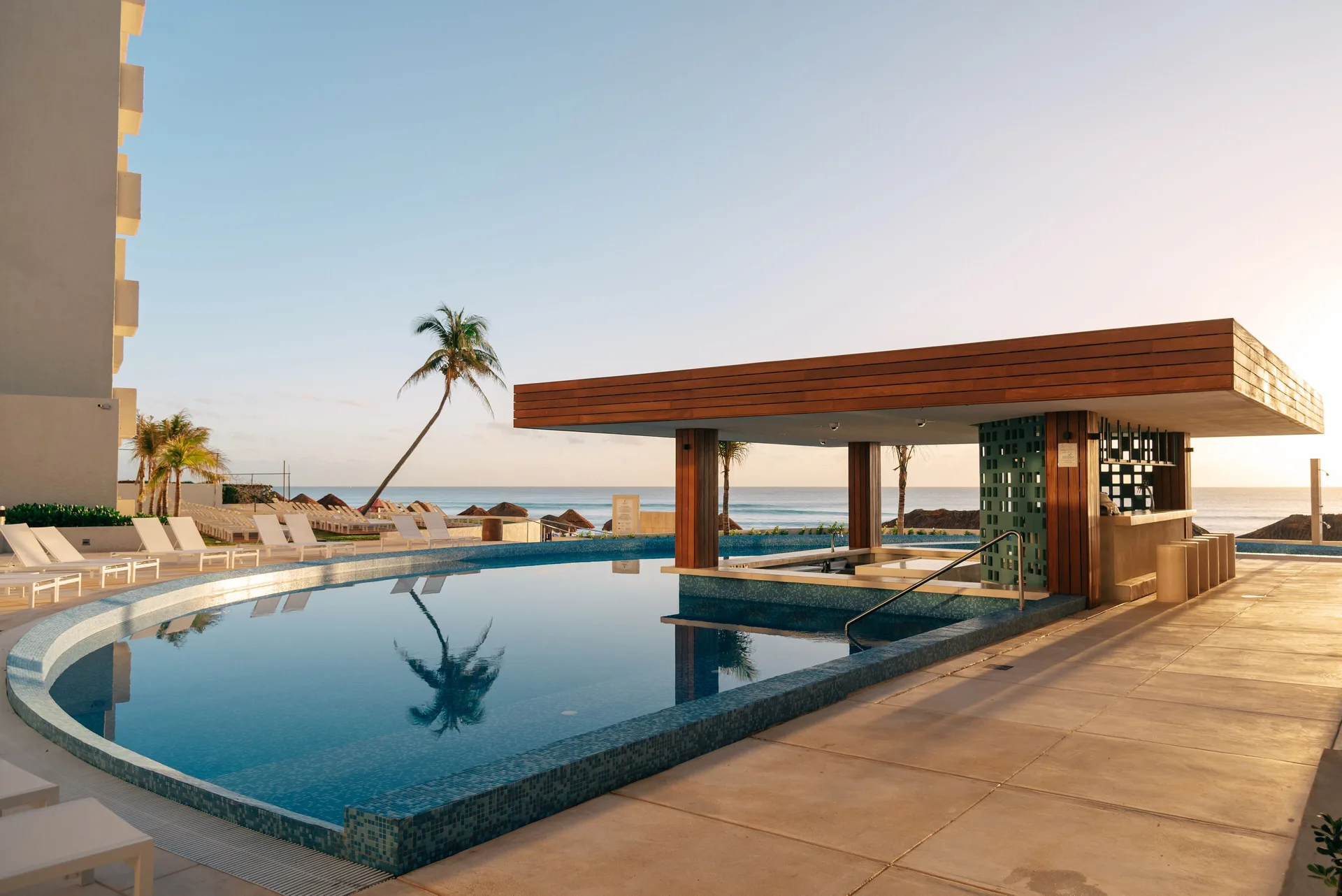 Poolside bar pavilion beside the water and ocean at Emporio Cancun.