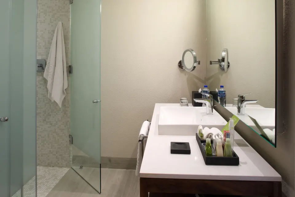Deluxe Doble Room Oceanfront bathroom vanity and glass shower at Emporio Cancun.