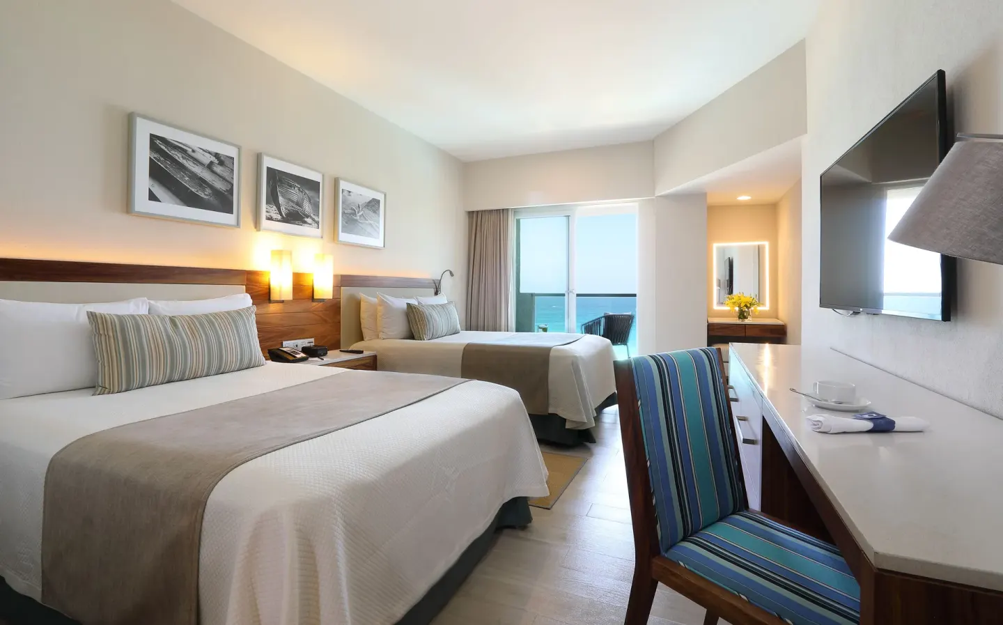Deluxe Doble Room Oceanfront with two beds, desk and balcony view at Emporio Cancun.