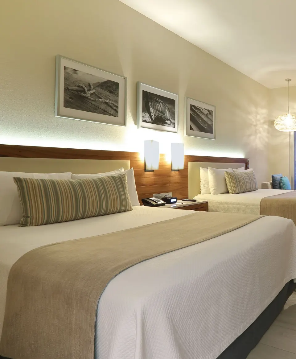 Deluxe Doble Room Oceanfront two-bed sleeping area at Emporio Cancun.