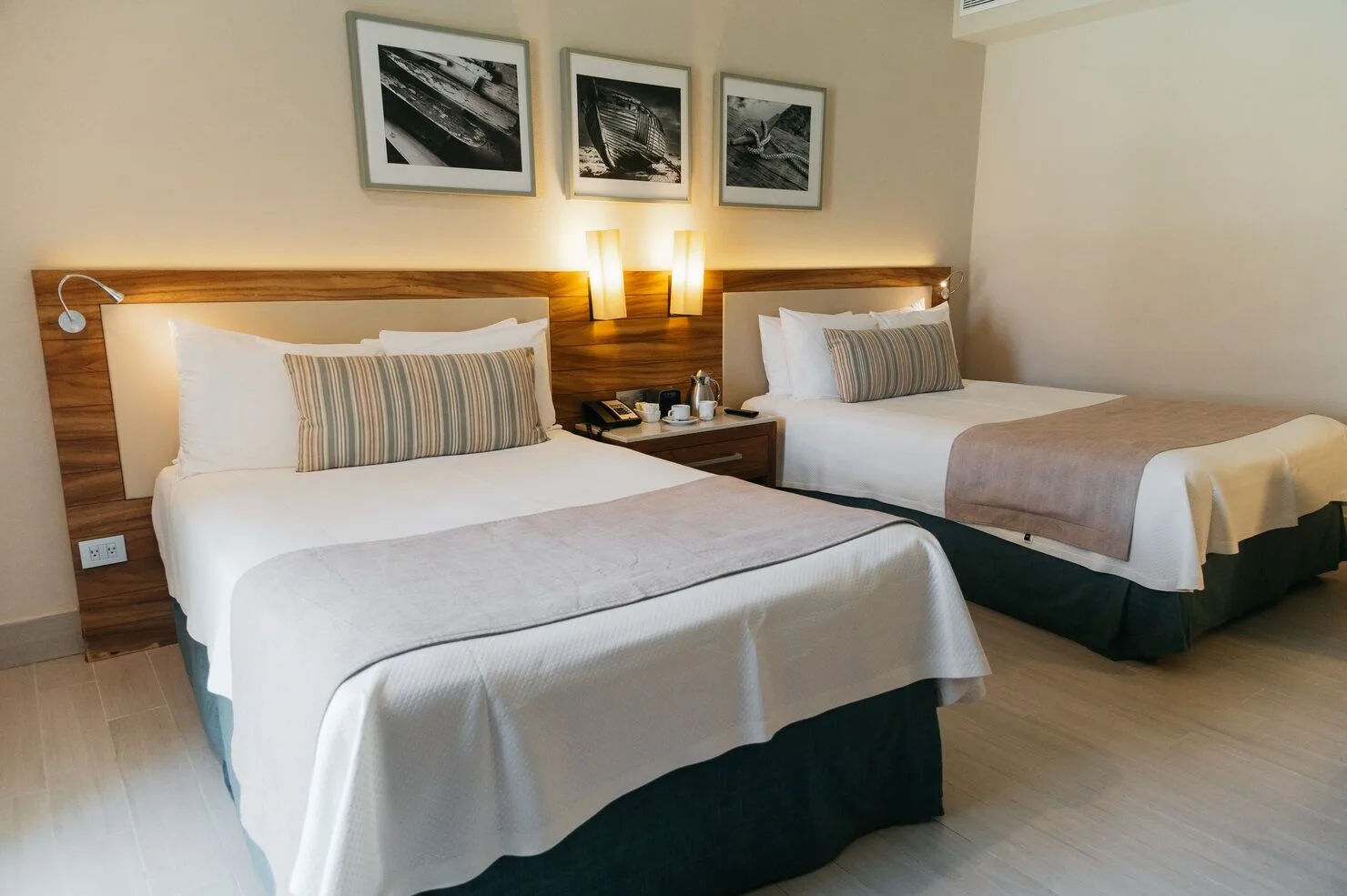 Super Saver room with two beds, wood headboards, and framed art at Emporio Cancun.