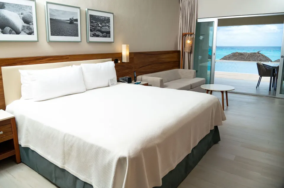 Swim Up Oceanfront Only Adults room with king bed and ocean-facing terrace at Emporio Cancun.
