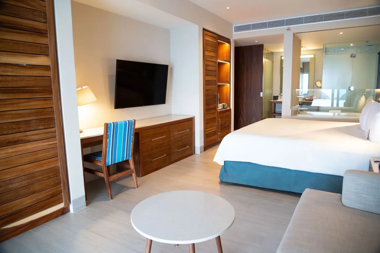 Swim Up Oceanfront Only Adults room with bed, sofa, desk, and TV at Emporio Cancun.