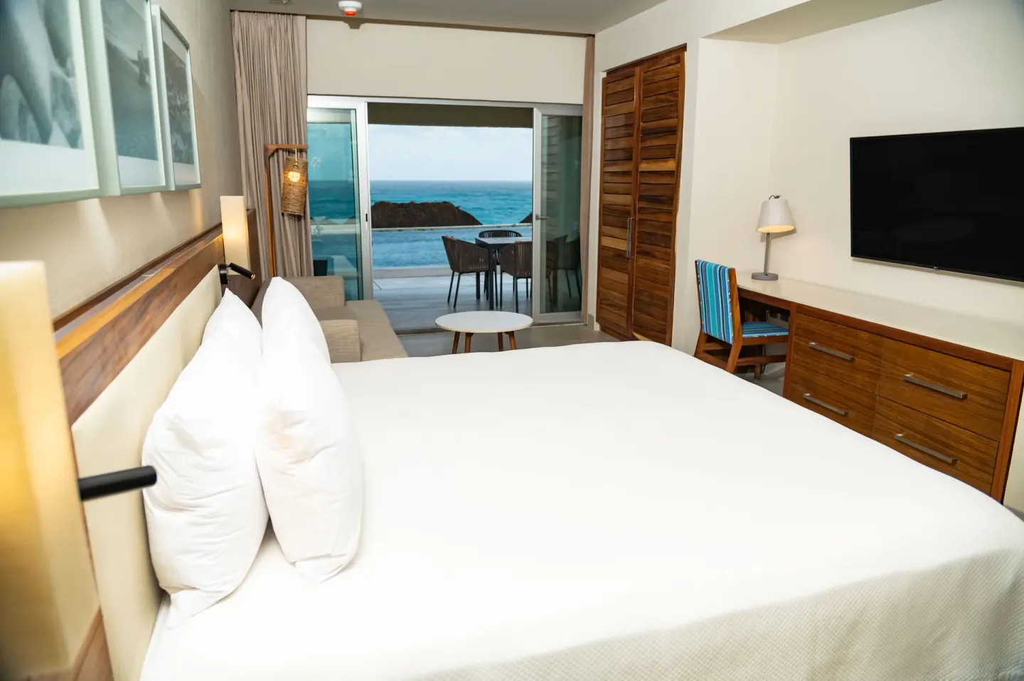 Swim Up Oceanfront Only Adults room with bed, desk, TV, and terrace at Emporio Cancun.
