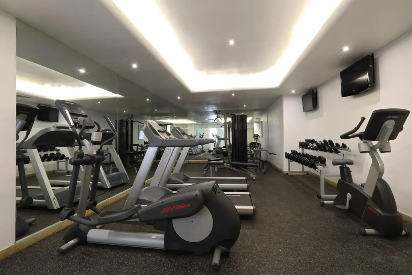 Fitness room with cardio machines and free weights at Emporio Ixtapa.