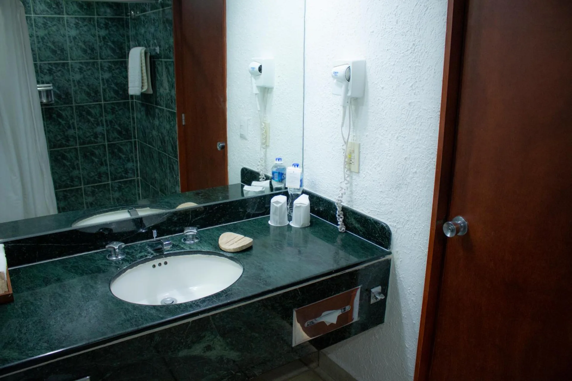 Guest bathroom sink and shower area at Emporio Ixtapa.