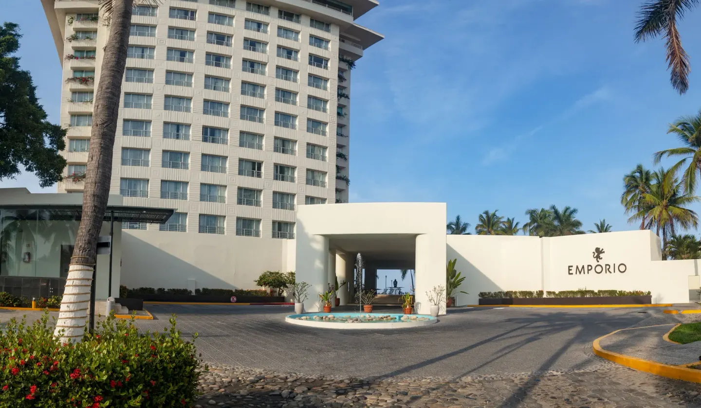 Hotel entrance driveway, tower, and Emporio sign at Emporio Ixtapa.