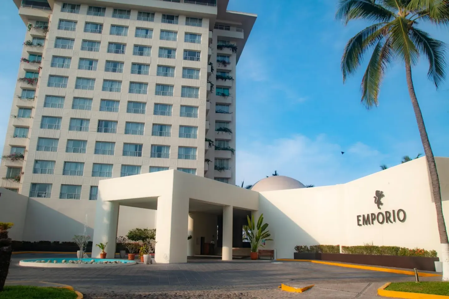 Emporio Ixtapa entrance with tower building, palm tree and front drive.