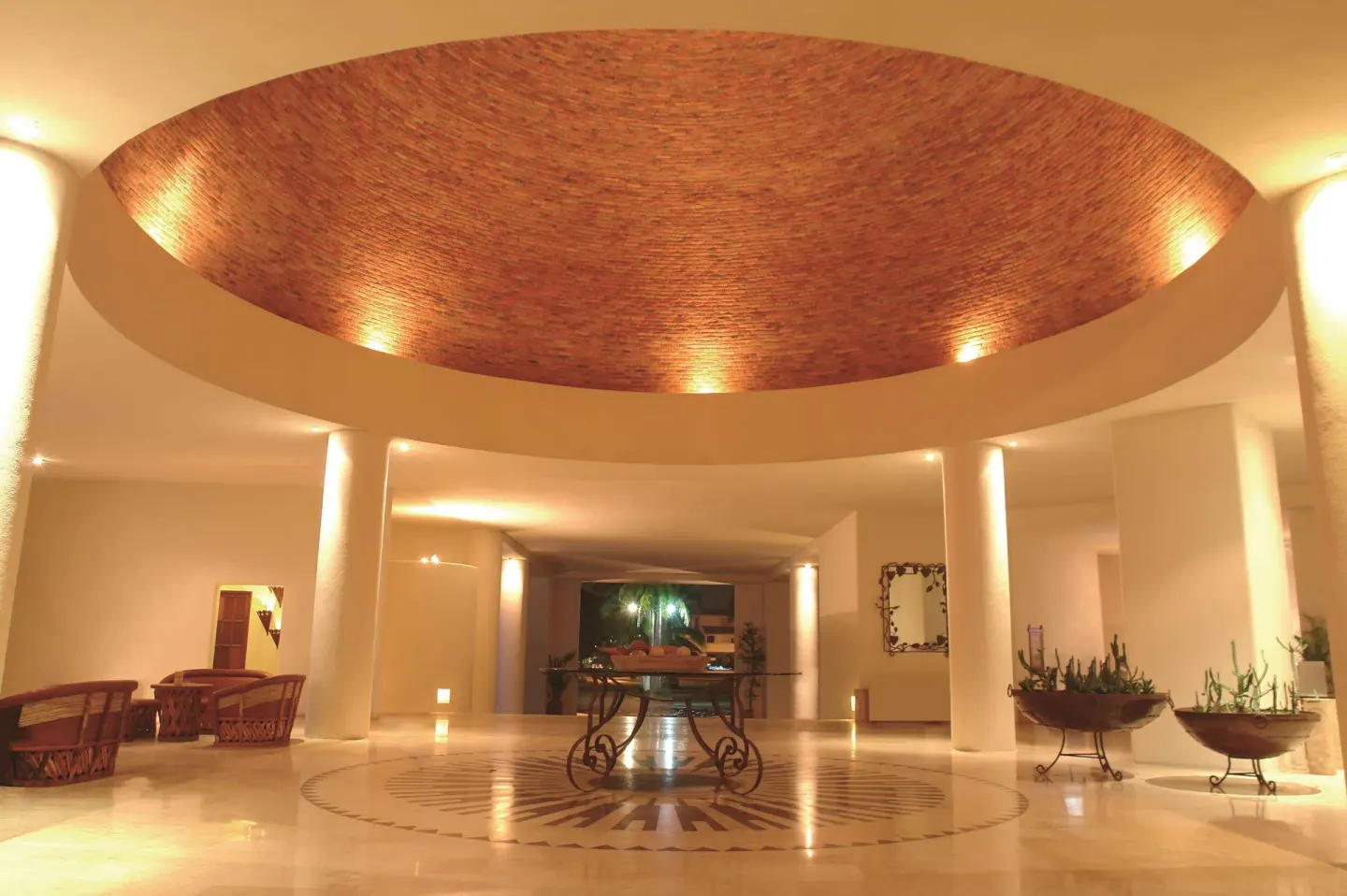 Lobby rotunda with brick ceiling feature and central table at Emporio Ixtapa.