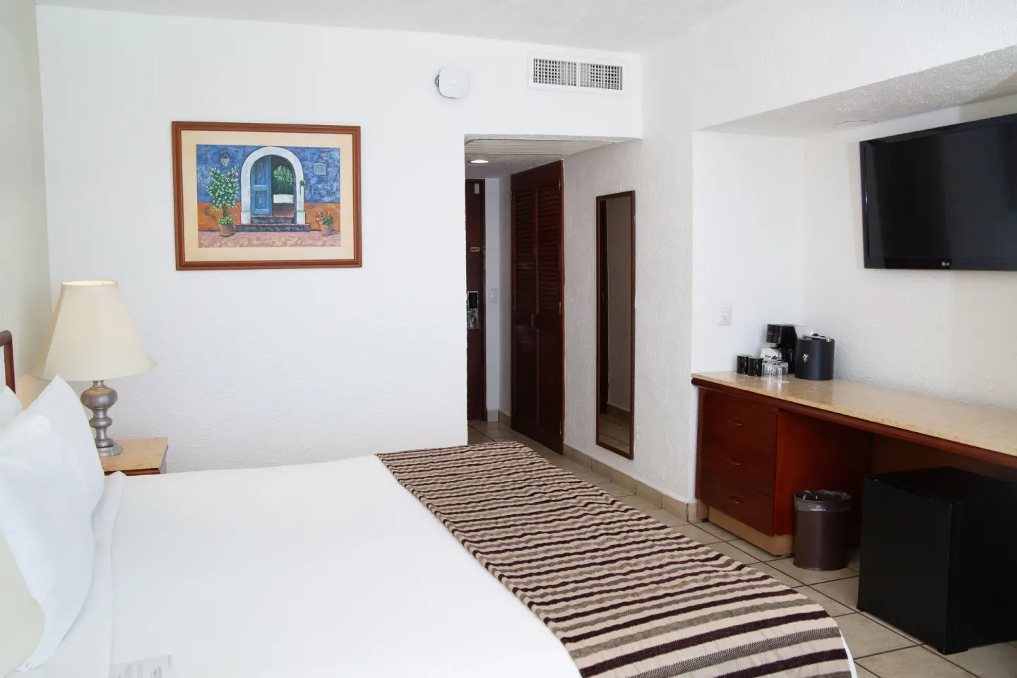 Superior Mountain View room with king bed, TV, desk, and mini fridge at Emporio Ixtapa.
