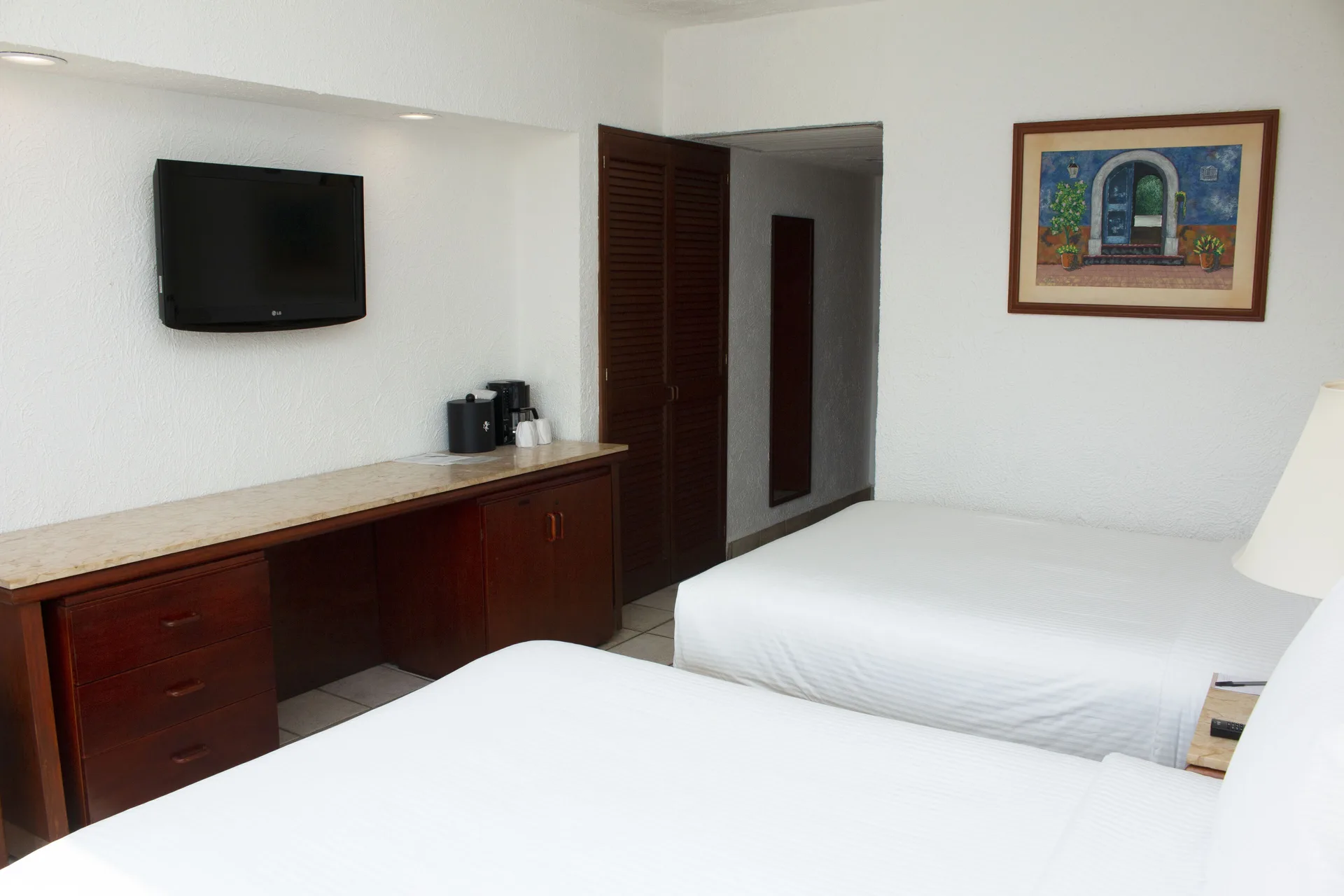 Superior Mountain View room with two beds, TV, and desk at Emporio Ixtapa.