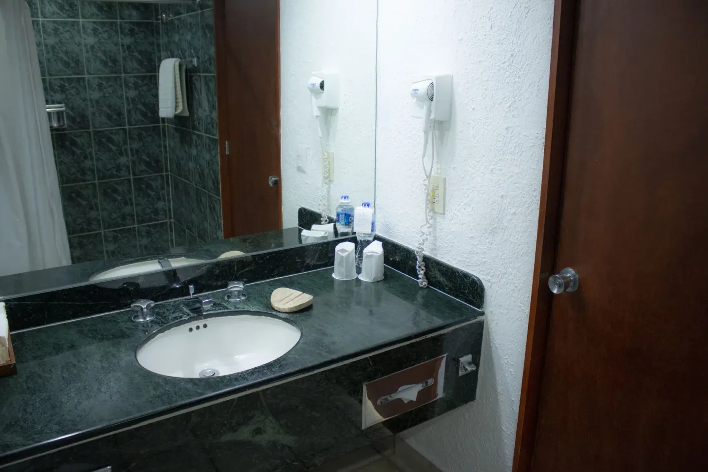 Bathroom vanity in a Superior Ocean View room at Emporio Ixtapa with sink, mirror, and hair dryer.