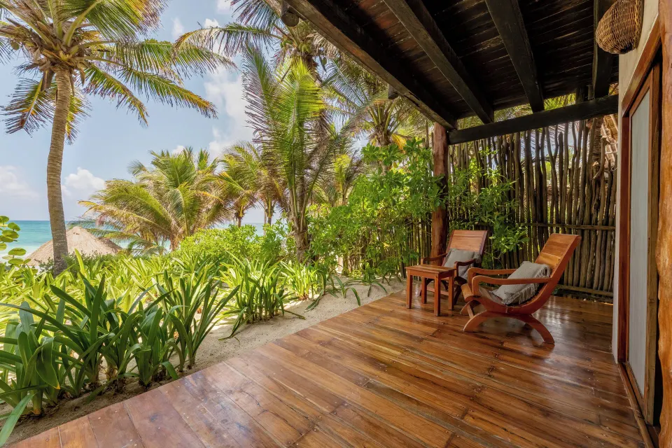 Wooden beachfront terrace with chairs and ocean view at Encantada Tulum