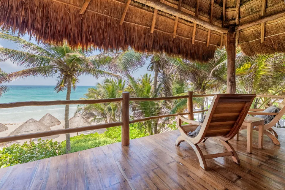 Ocean-facing palapa balcony with lounge chairs at Encantada Tulum