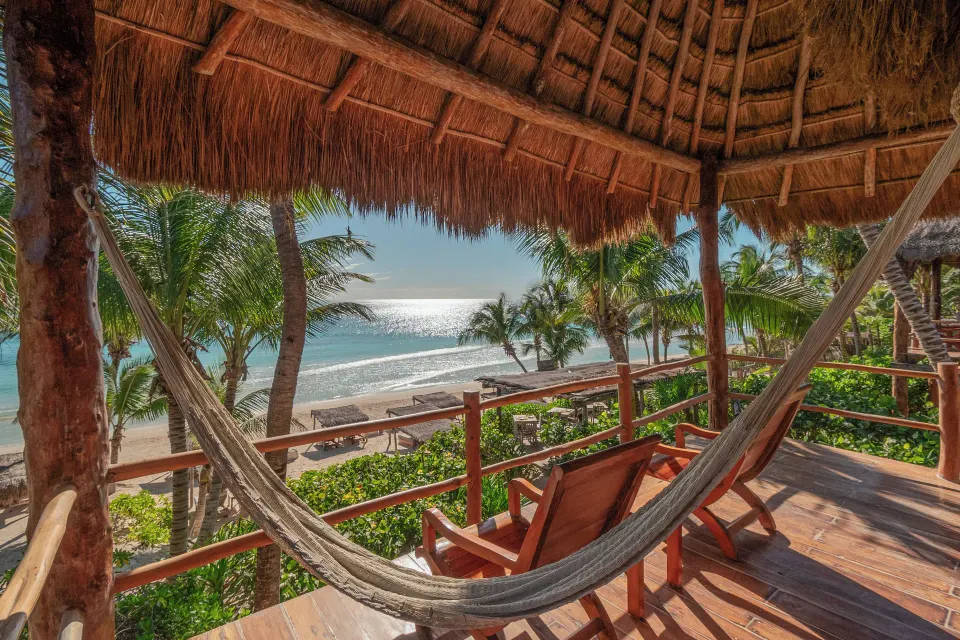 Thatched balcony with hammock and ocean view at Encantada Tulum