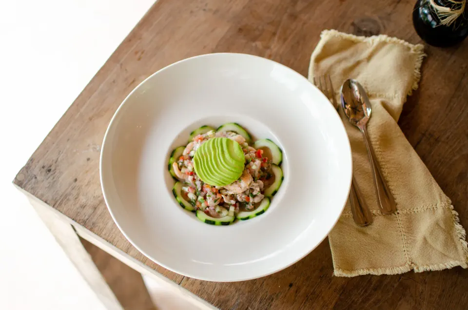 Two bowls of food on a rustic table in a bright dining nook at Encantada Tulum.