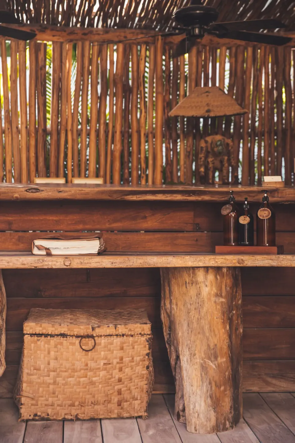 Rustic wooden bar counter and woven basket detail inside Encantada Tulum