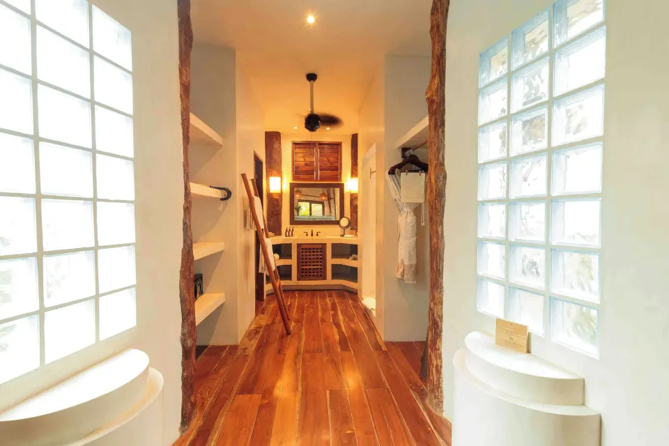 Walkway to the bathroom and dressing area with glass block windows in a Garden View Room at Encantada Tulum.