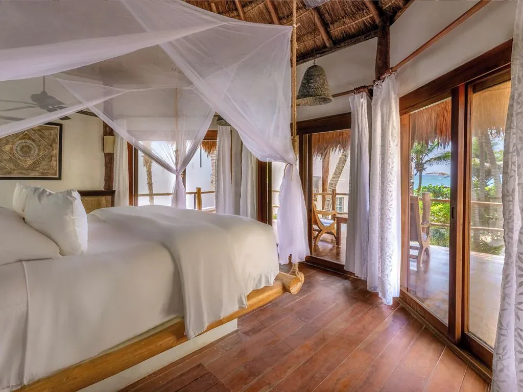 Partial Ocean View Room interior with king bed and canopy at Encantada Tulum