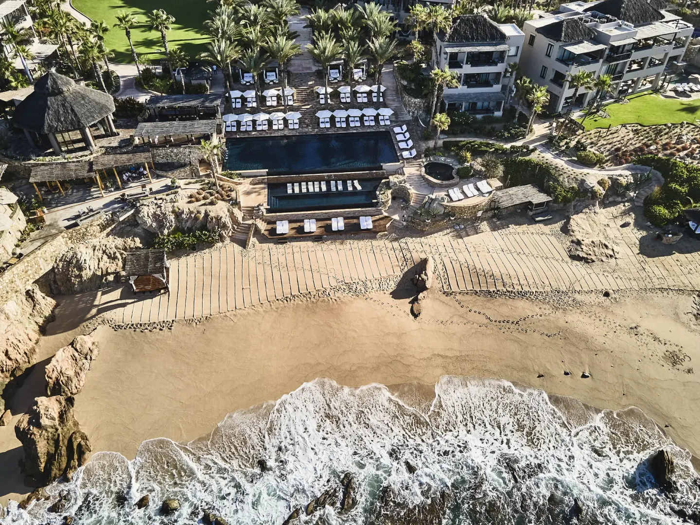 Aerial view of the beach, pools, palms, and resort buildings at Esperanza.
