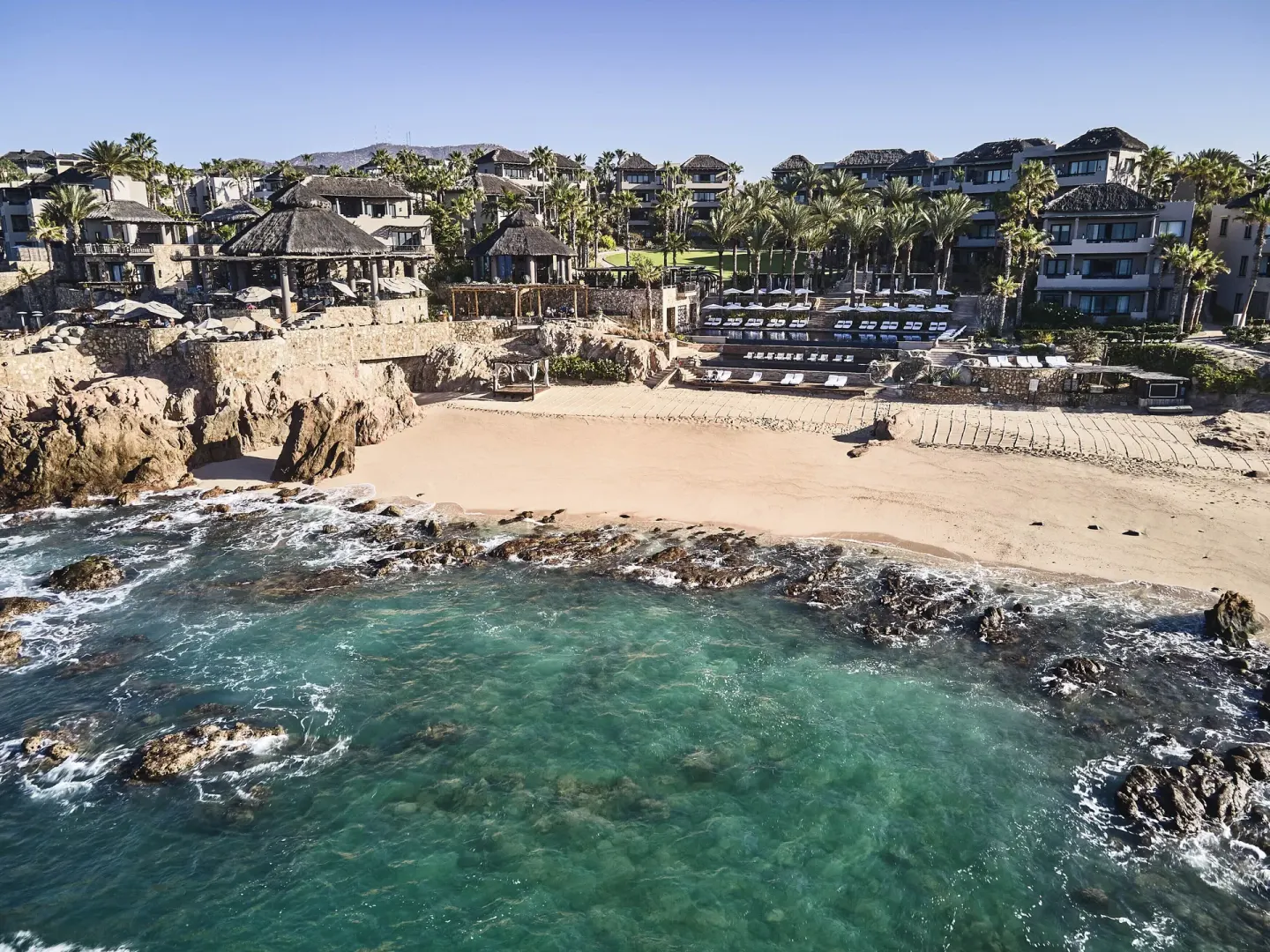Aerial view of Esperanza above a rocky beach and turquoise shoreline.