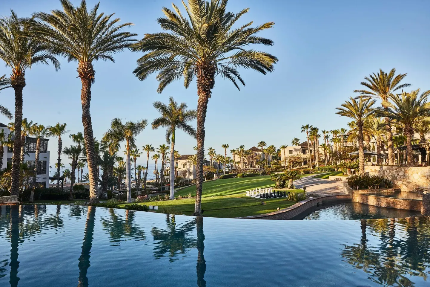 Infinity pool with palm trees, lawns and resort buildings at Esperanza.