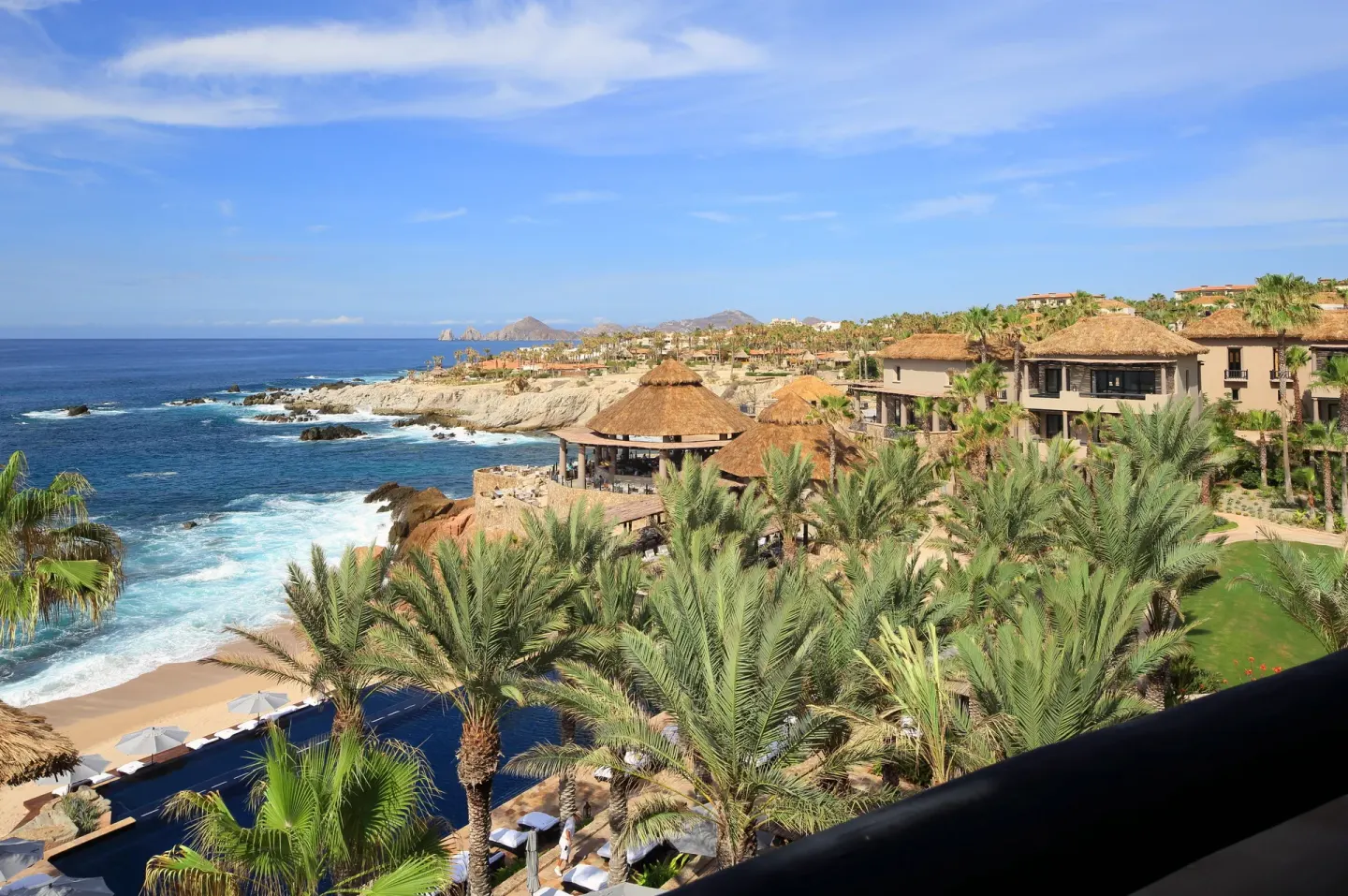 Oceanfront resort buildings, palms, pools, and coastline at Esperanza.