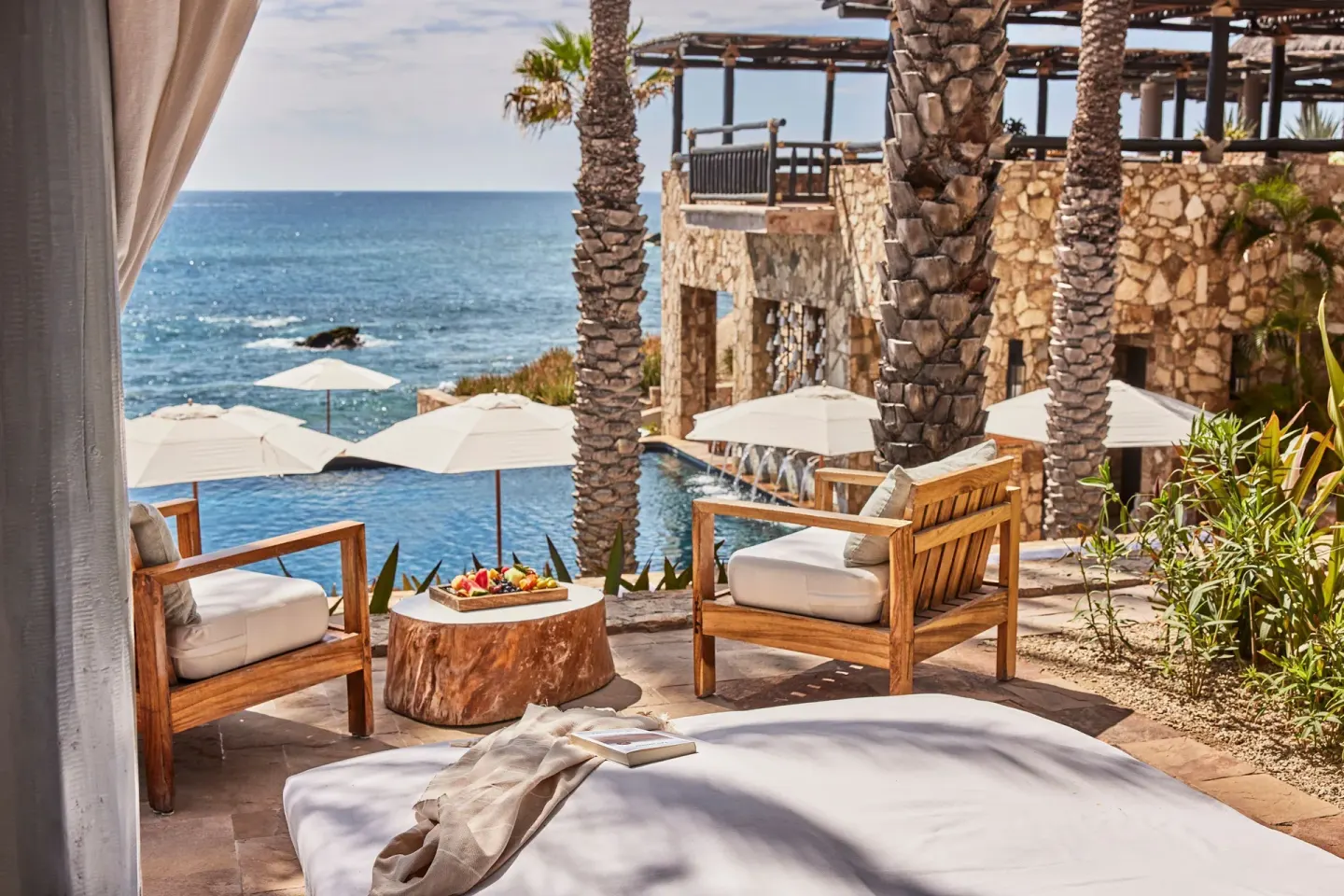 Oceanfront terrace seating with umbrellas and palm trees at Esperanza.