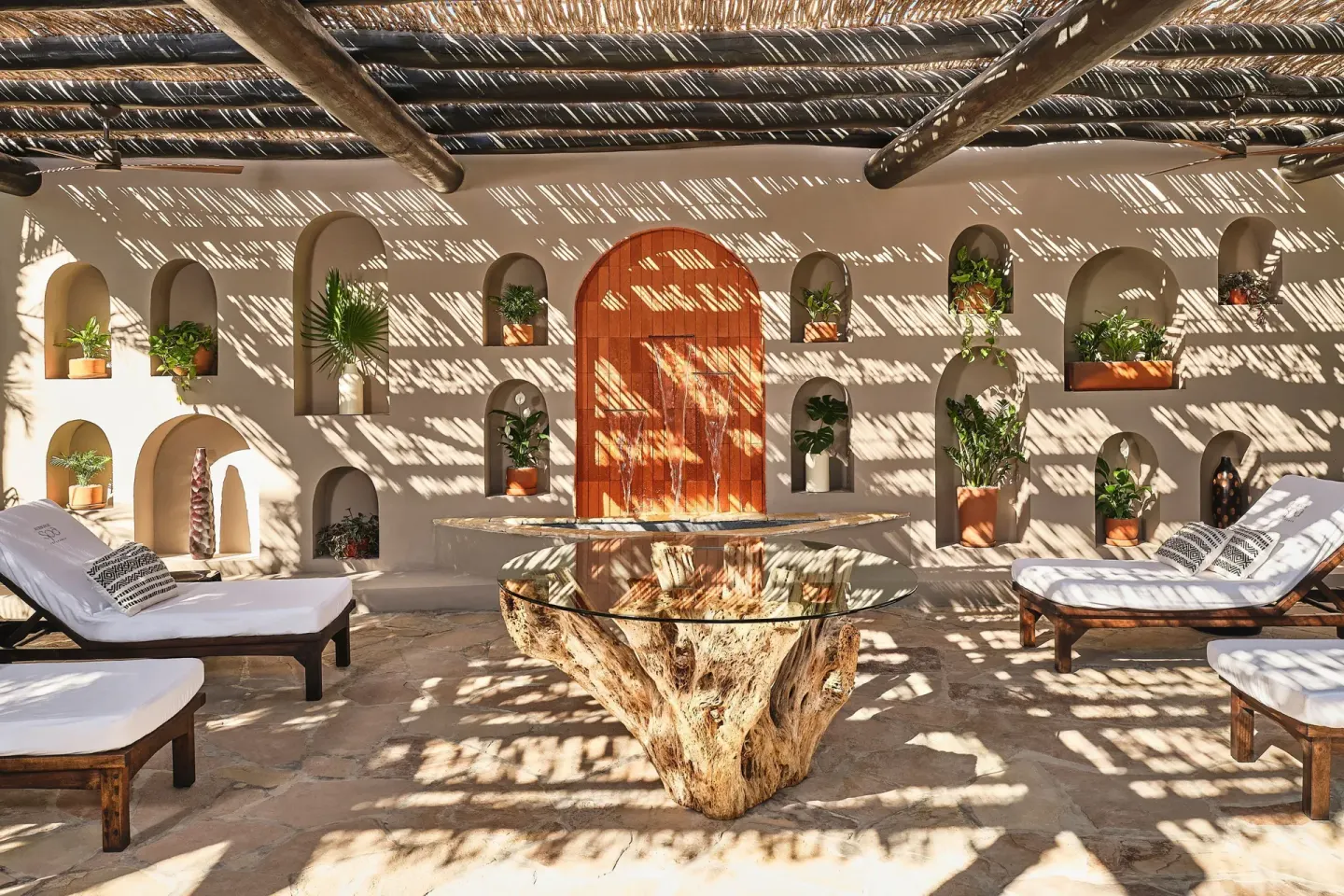 Shaded lounge patio with daybeds and plant niches at Esperanza.