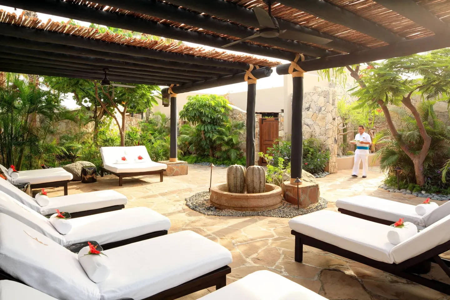 Spa garden lounge with white daybeds beneath a pergola at Esperanza.