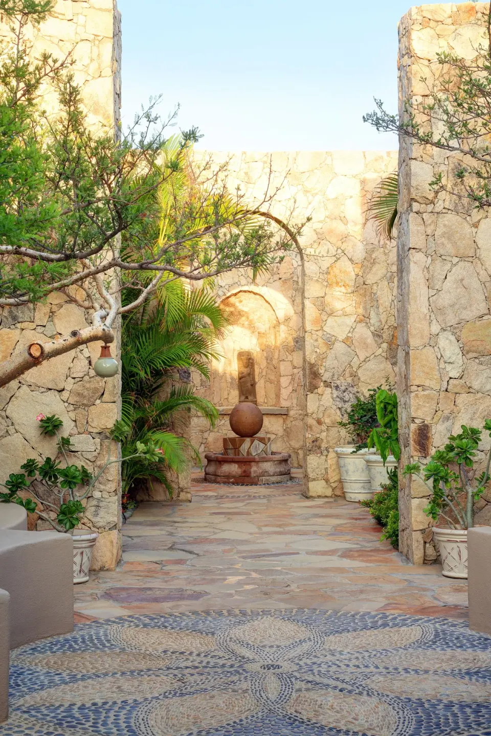 Stone courtyard with fountain and tropical plants at Esperanza.