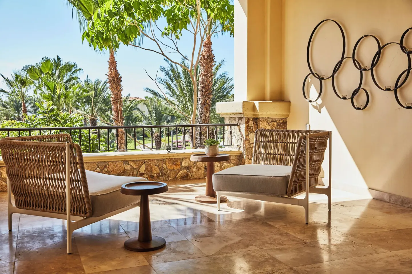 Covered terrace with cushioned lounge chairs and palm views at a three-bedroom casona at Esperanza.