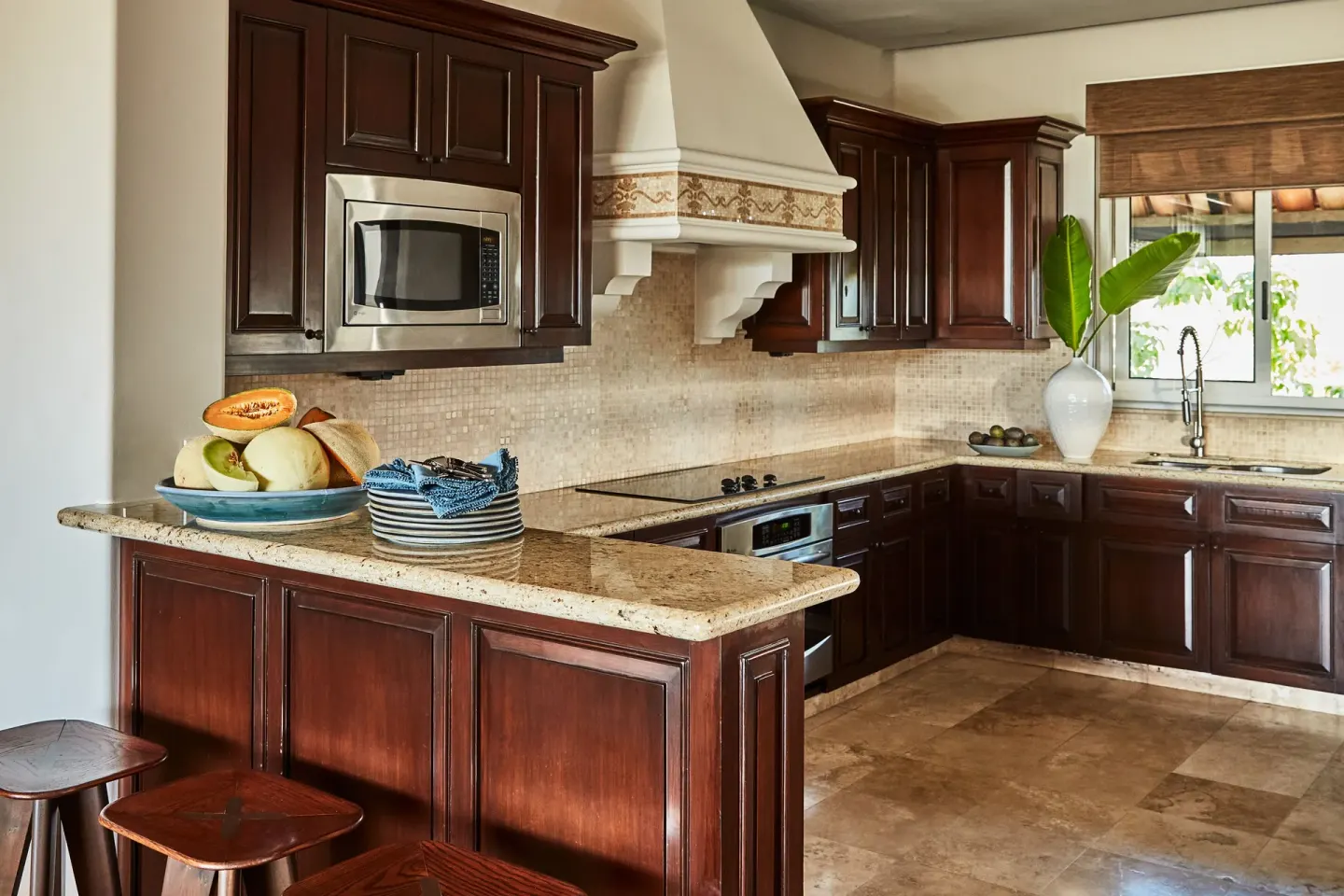 Full kitchen with dark wood cabinetry and stone counters in a three-bedroom casona at Esperanza.