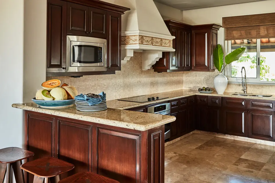 Full kitchen with dark wood cabinetry and stone counters in a three-bedroom casona at Esperanza.