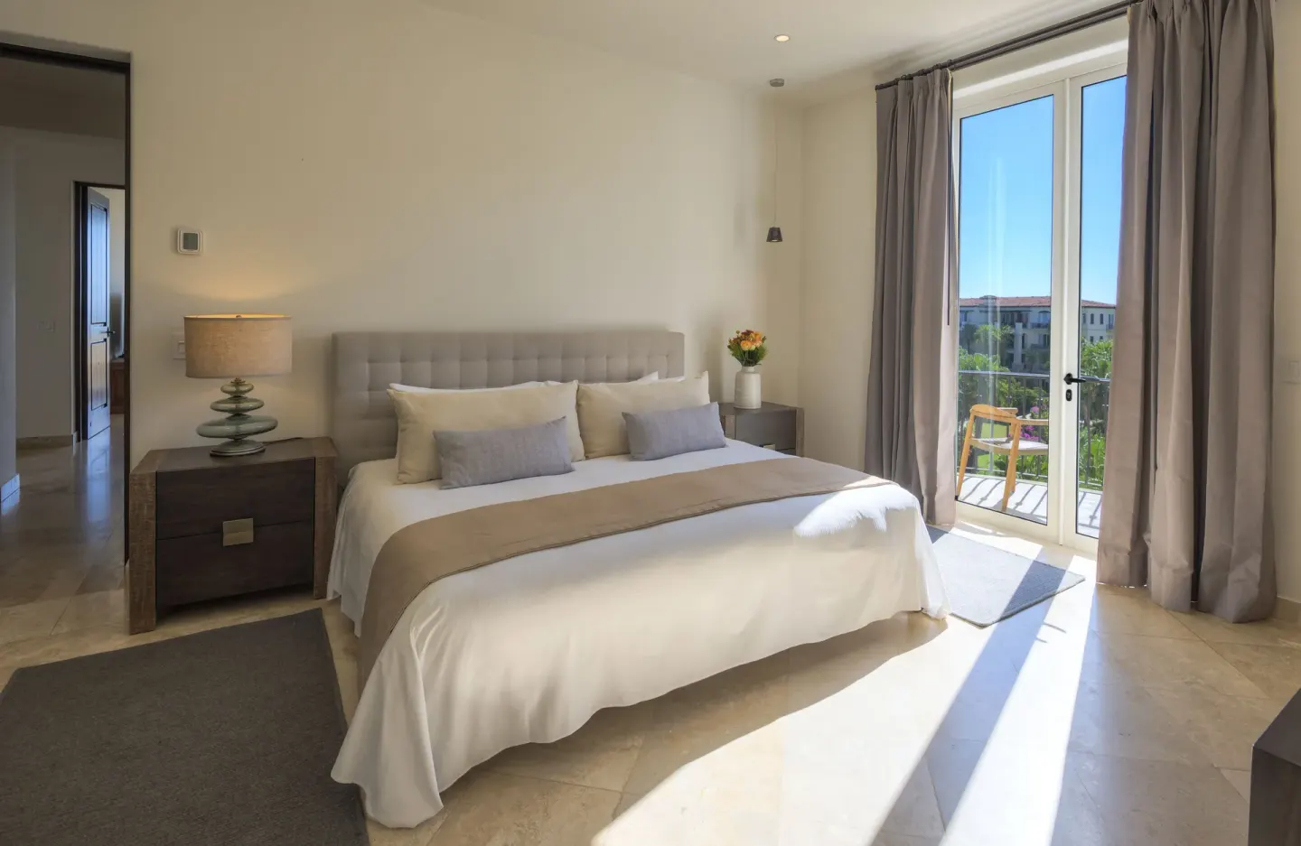 Guest bedroom with king bed and glass doors to a balcony at Esperanza.
