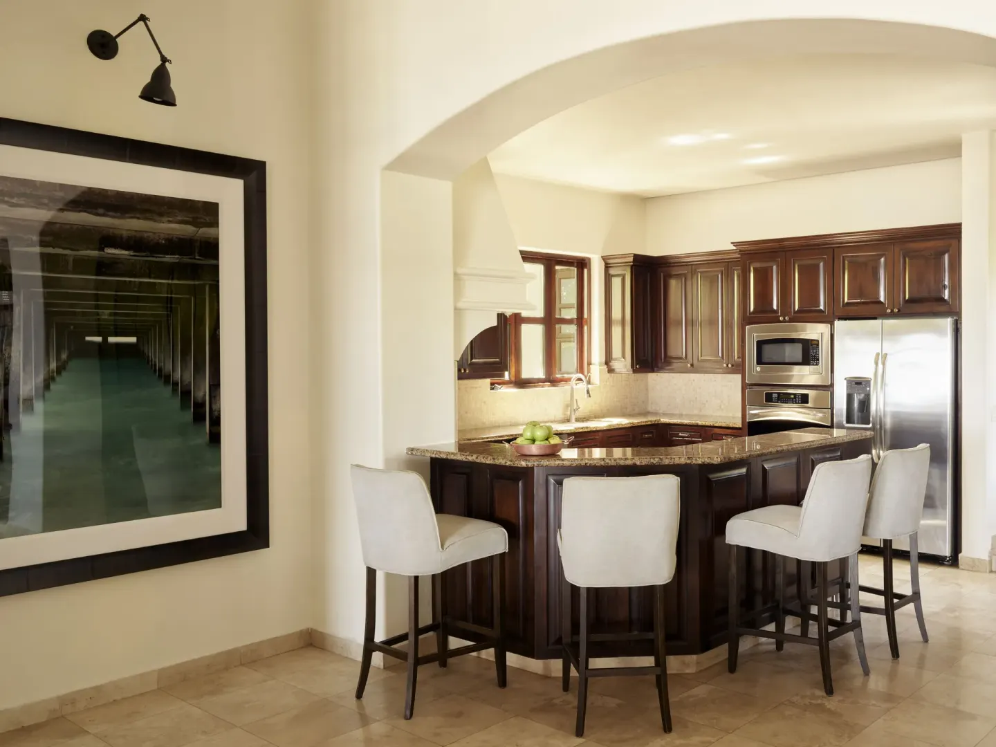Kitchen with dark wood cabinets, island seating, and wall art at Esperanza.