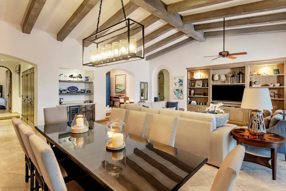 Living and dining room with beamed ceiling and built-in media wall at Esperanza.